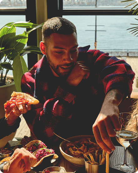 Man eating fries with tacos and pizza