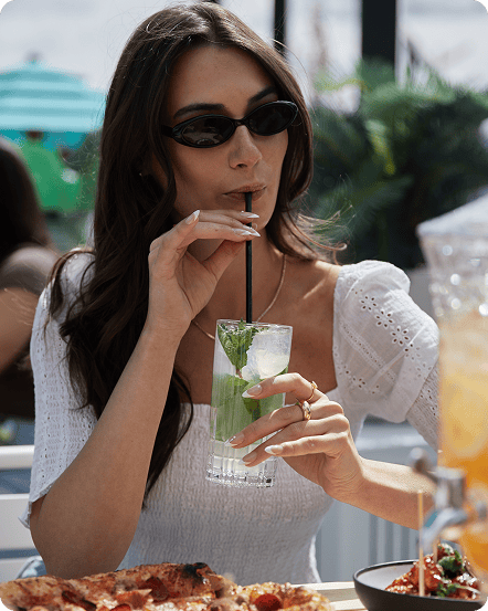 Woman drinking a cocktail at King Taps' patio